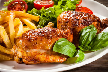 Grilled chicken legs with chips and vegetables 
