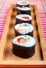 Sushi on a wooden platter and bamboo mat