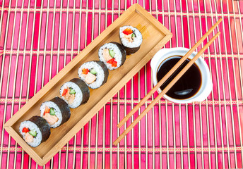 Sushi on a wooden platter and bamboo mat