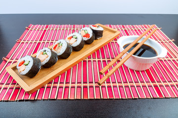Sushi on a wooden platter and bamboo mat