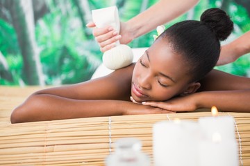 Obraz na płótnie Canvas Pretty woman enjoying a herbal compress massage