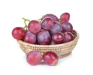 red grapes in basket on white background