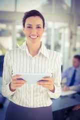 Obraz premium Businesswoman holding tablet and looking at camera 