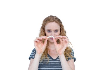 Serious blonde woman snapping cigarette 