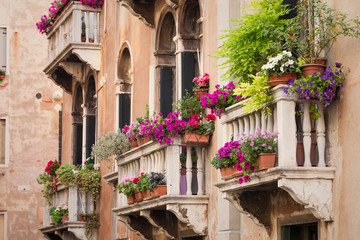 Fototapeta na wymiar Beautiful old building balconies with colorful flowers