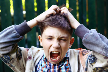 preteen handsome boy scratch his head