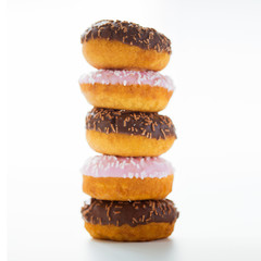close up of glazed donuts pile over white