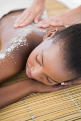 Obraz na płótnie Canvas Pretty woman enjoying a salt scrub massage