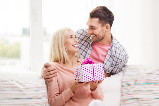 happy man giving woman gift box at home