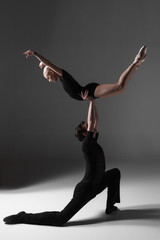 two young modern ballet dancers on gray studio background 