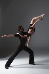 two young modern ballet dancers on gray studio background 