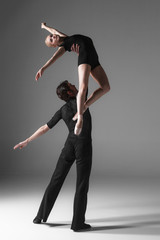 two young modern ballet dancers on gray studio background 