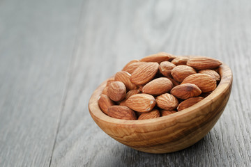 roasted almonds in bowl on gray wooden table