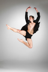 Fototapeta premium The young attractive modern ballet dancer jumping on white