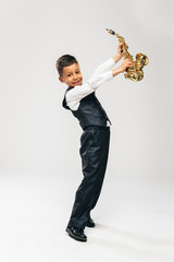 six years old boy brings saxophone over his head