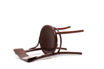 Brown wooden chair fallen down on the floor