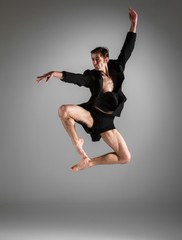 Fototapeta premium The young attractive modern ballet dancer jumping on white