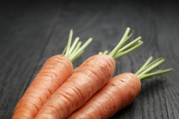 fresh organic carrots on wooden table