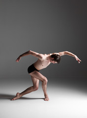 The young attractive modern ballet dancer on white background