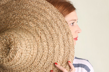 Side view of young woman with big straw hat