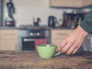 Hand placing cup on table