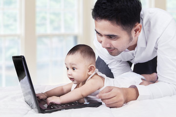 Cute baby looks curious with laptop