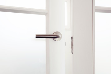 Open white door with metallic handle