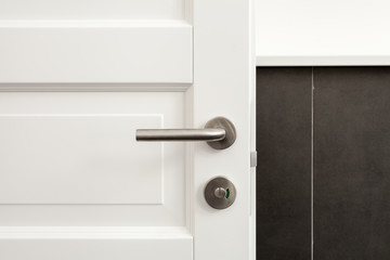 Open white door with metallic handle