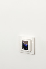 Digital climate control on white wall
