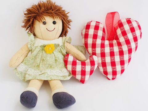 Little doll with two soft stuffed hearts, small and big