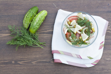 Salad of cooked squid, fresh vegetables and herbs in glass bowl