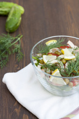 Salad of cooked squid, fresh vegetables and herbs in glass bowl