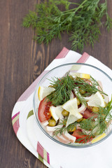 Salad of cooked squid, fresh vegetables and herbs in glass bowl