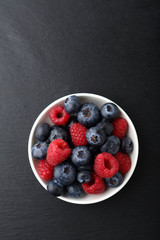 raspberries and blueberries in a bowl