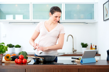 Young woman in the kitchen with tablet pc III