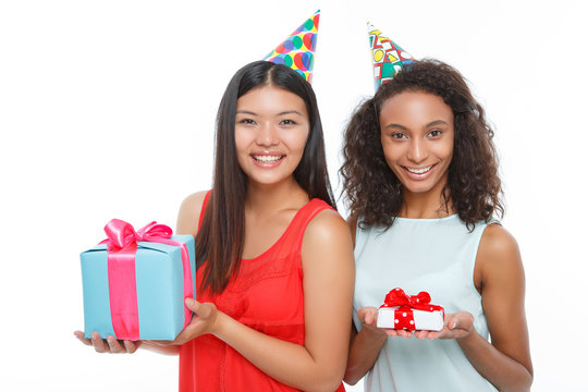 Cheerful girls holding birthday presents 