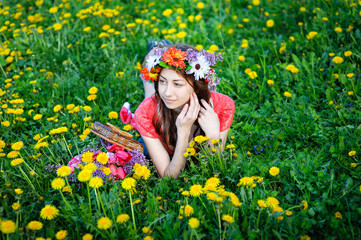 beautiful woman sitting in a wreath on a meadow