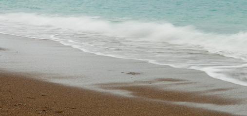 Seashore waves with sandy beach  background