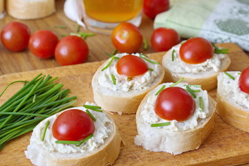 bread pieces with vegetable spread, chive and tomatoes