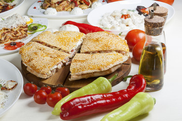 Large, baked, stuffed sandwich served on a table.