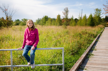 teen girl sitting and thinking on a nature trail