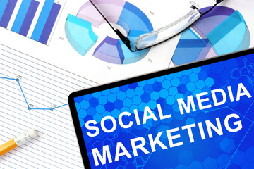 Tablet with social media marketing, graphs and glasses. Marketing concept.