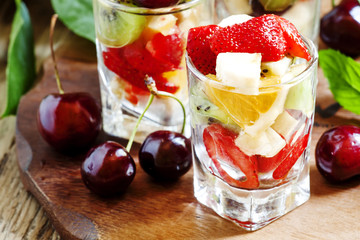 Salad from fruit and berries in glasses, selective focus
