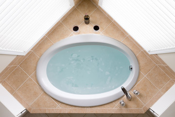 Stylish corner oval bathtub in a tile surround