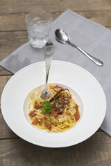 Dish of traditional spaghetti a la carbonara  with bacon , fork