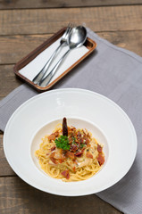 Dish of traditional spaghetti a la carbonara  with bacon , fork