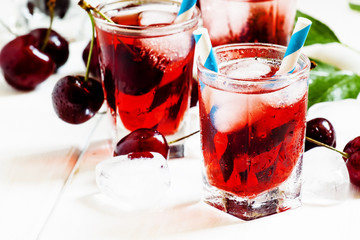 Cherry red drink with ice in a heart shape, selective focus