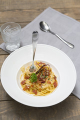 Dish of traditional spaghetti a la carbonara  with bacon , fork