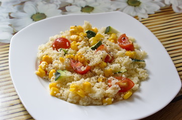 couscous served with corns, zucchini and tomatoes