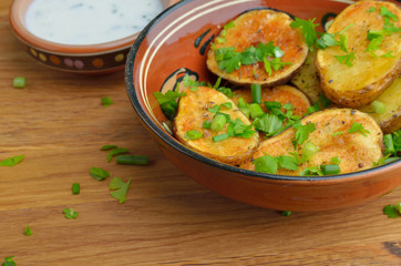 Roasted potato in bowl on wooden table